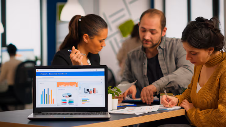 business-woman-talking-about-financial-project-taking-notes-discussing-start-up-ideas-using-laptop-diverse-employees-gathered-co-working-working-process-busy-company-teamwork-help-concept_482257-13564